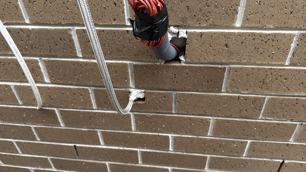 Service penetrations through the brick wall left unsealed against the weather, Kalkallo